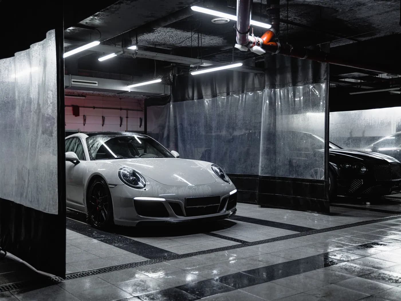 Porsche blanche dans un box de lavage professionnel